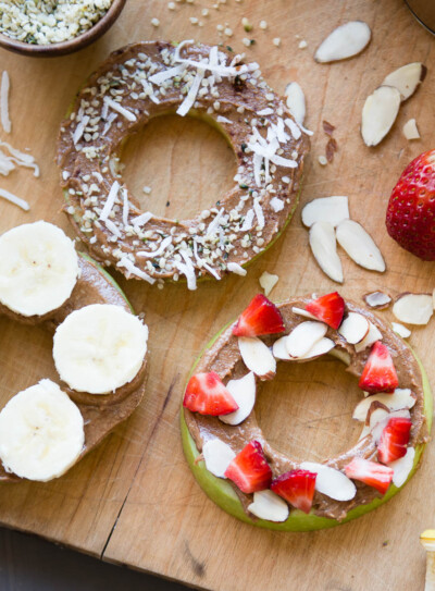 apple snacks topped with fresh fruit, nut butter and coconut flakes.