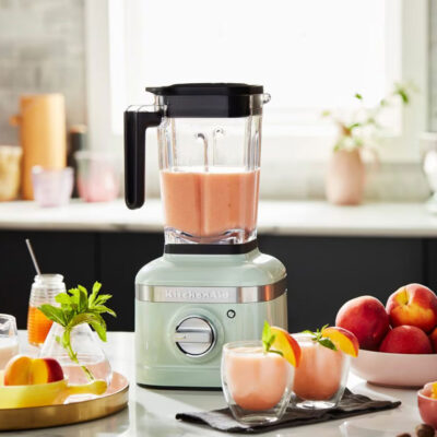 Blender for smoothies in kitchen with peaches.