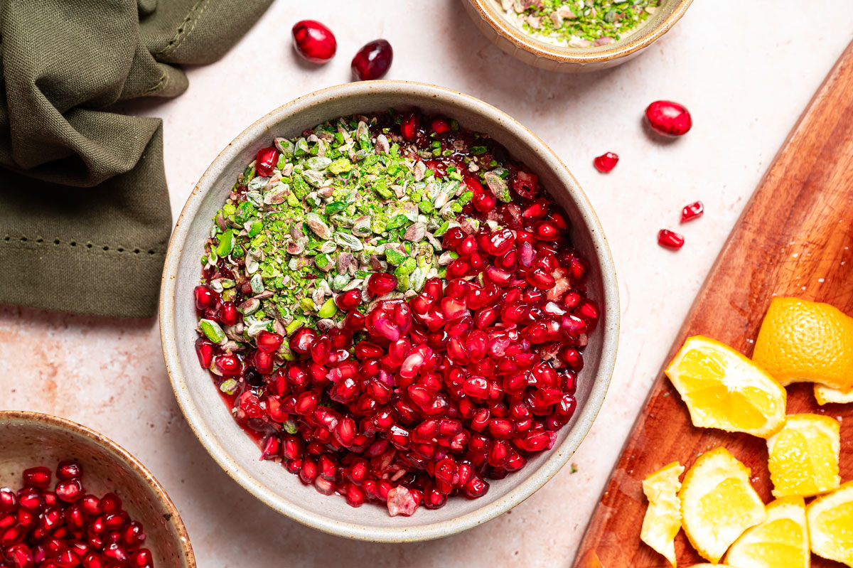 Bowl of pomegranate orals and pistachios.
