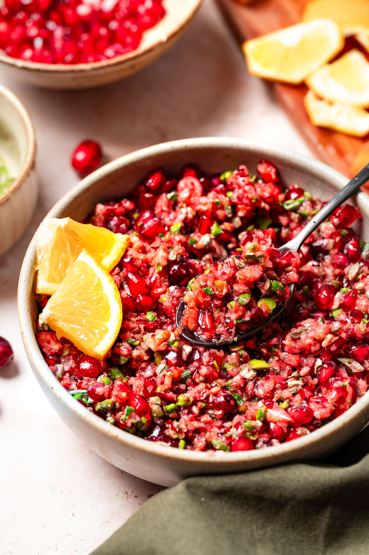 Serving homemade cranberry relish out of a pottery bowl with a black spoon.