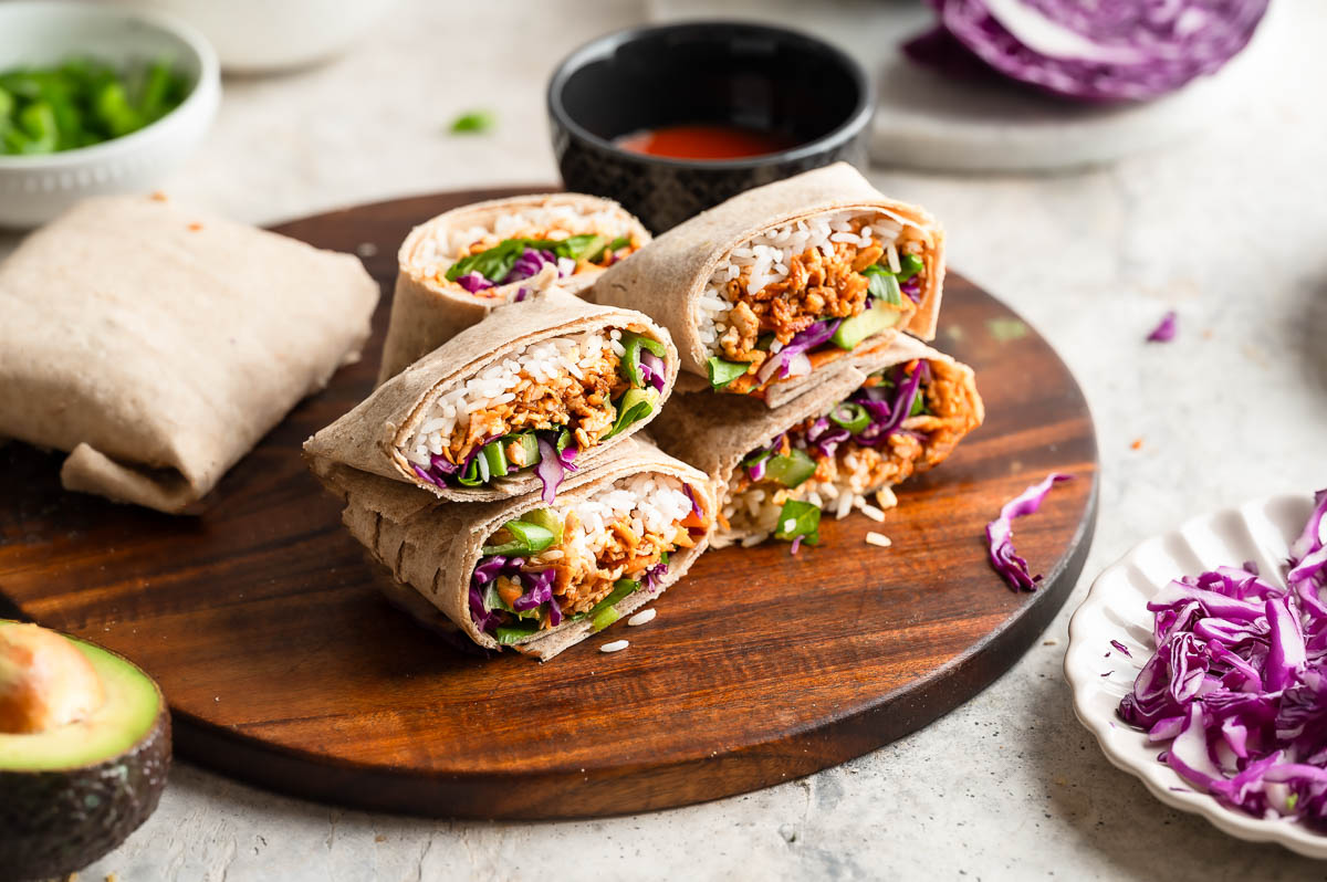 Buffalo tofu wraps with sauce and avocado ready to eat.
