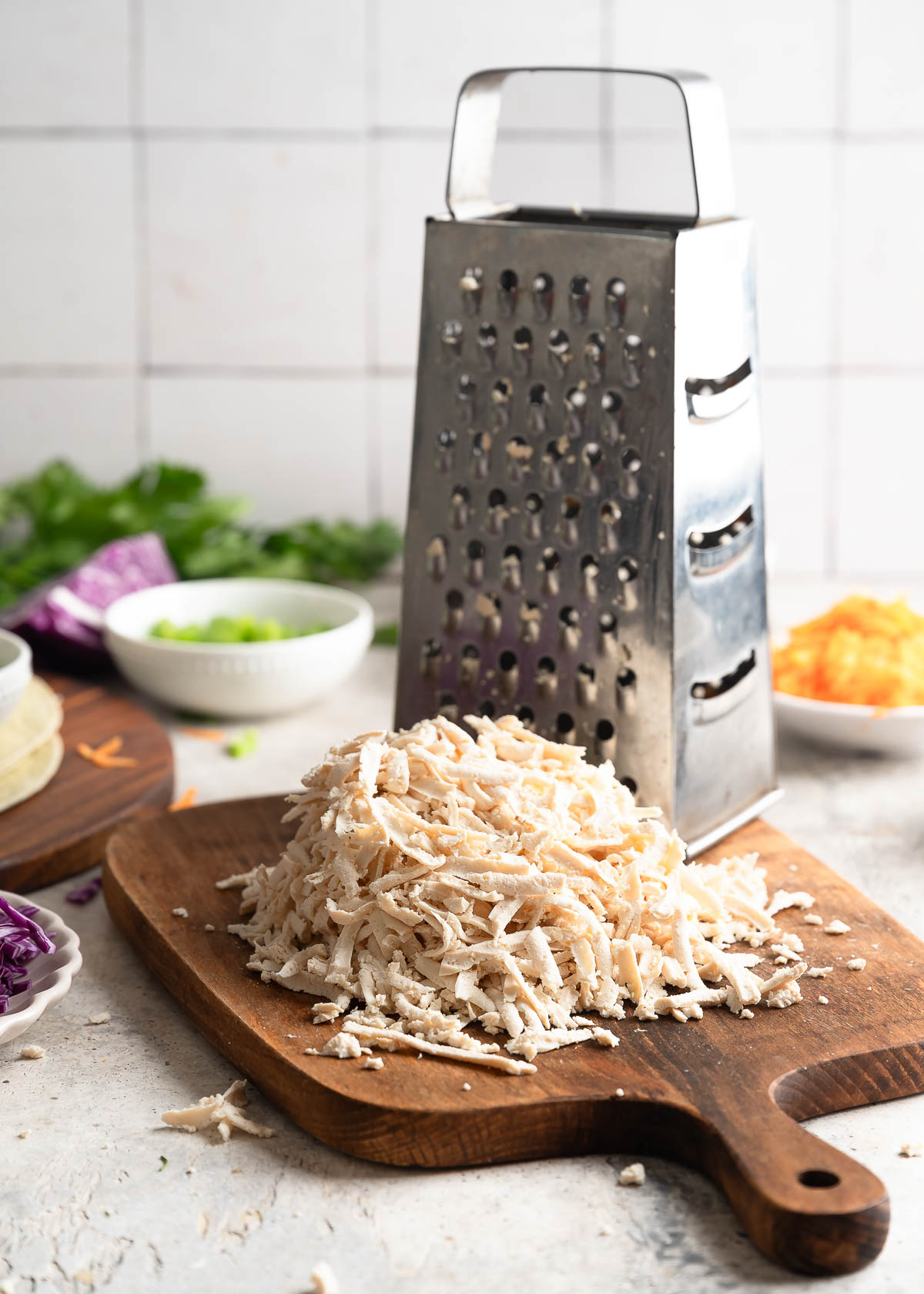 Pile of finely shredded tofu on a wooden cutting board. 