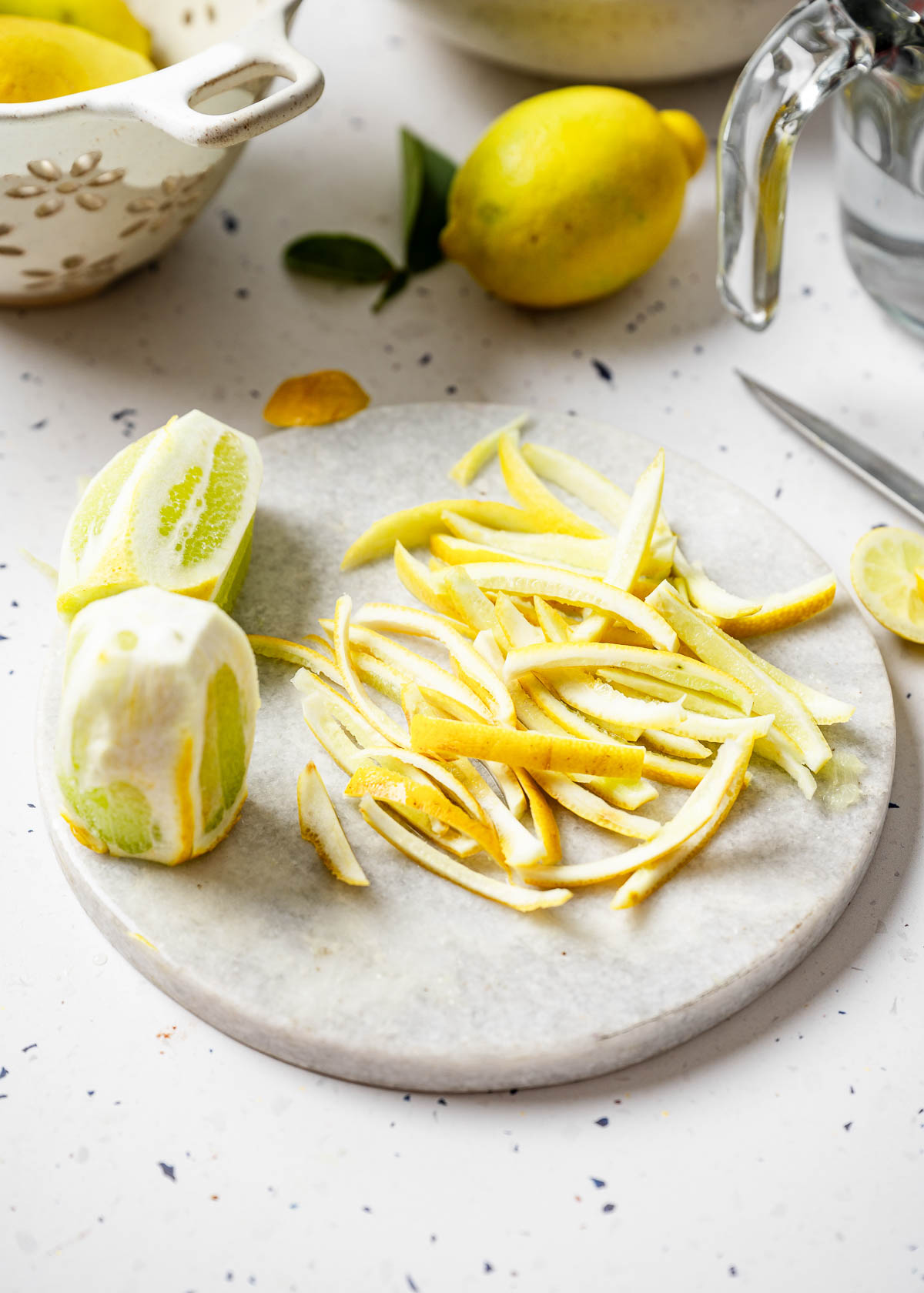 Cut lemon peels on a marble surface.