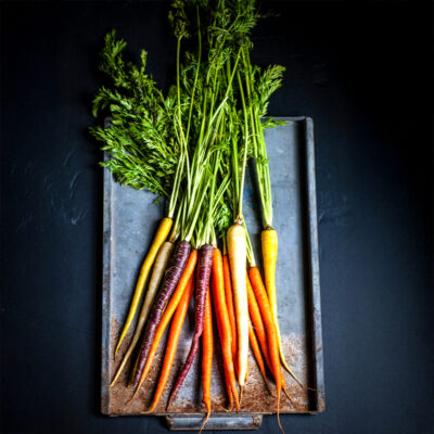 Bunch of freshly picked carrot tops on baking sheet.