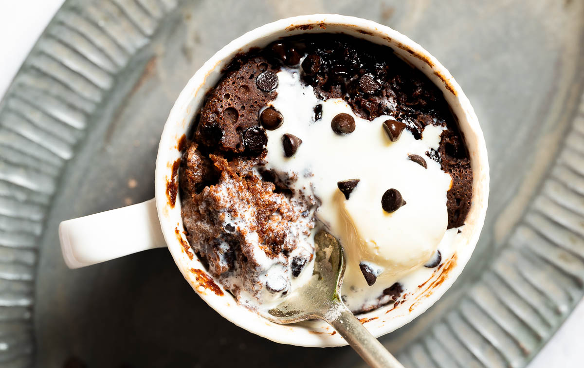 Vegan ice cream melton on top of a vegan chocolate mug cake recipe.