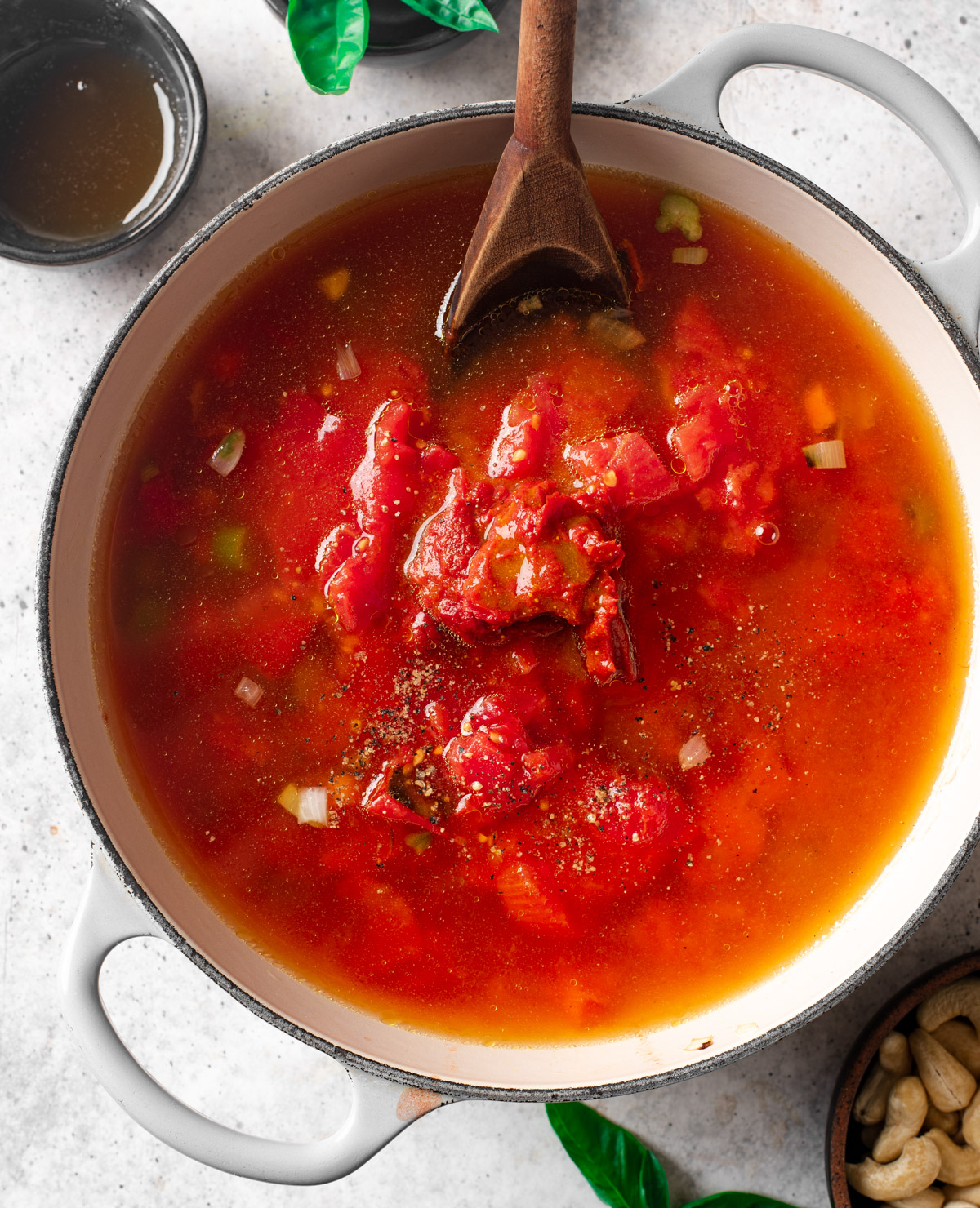 Adding can of fire-roasted tomatoes to soup pot.