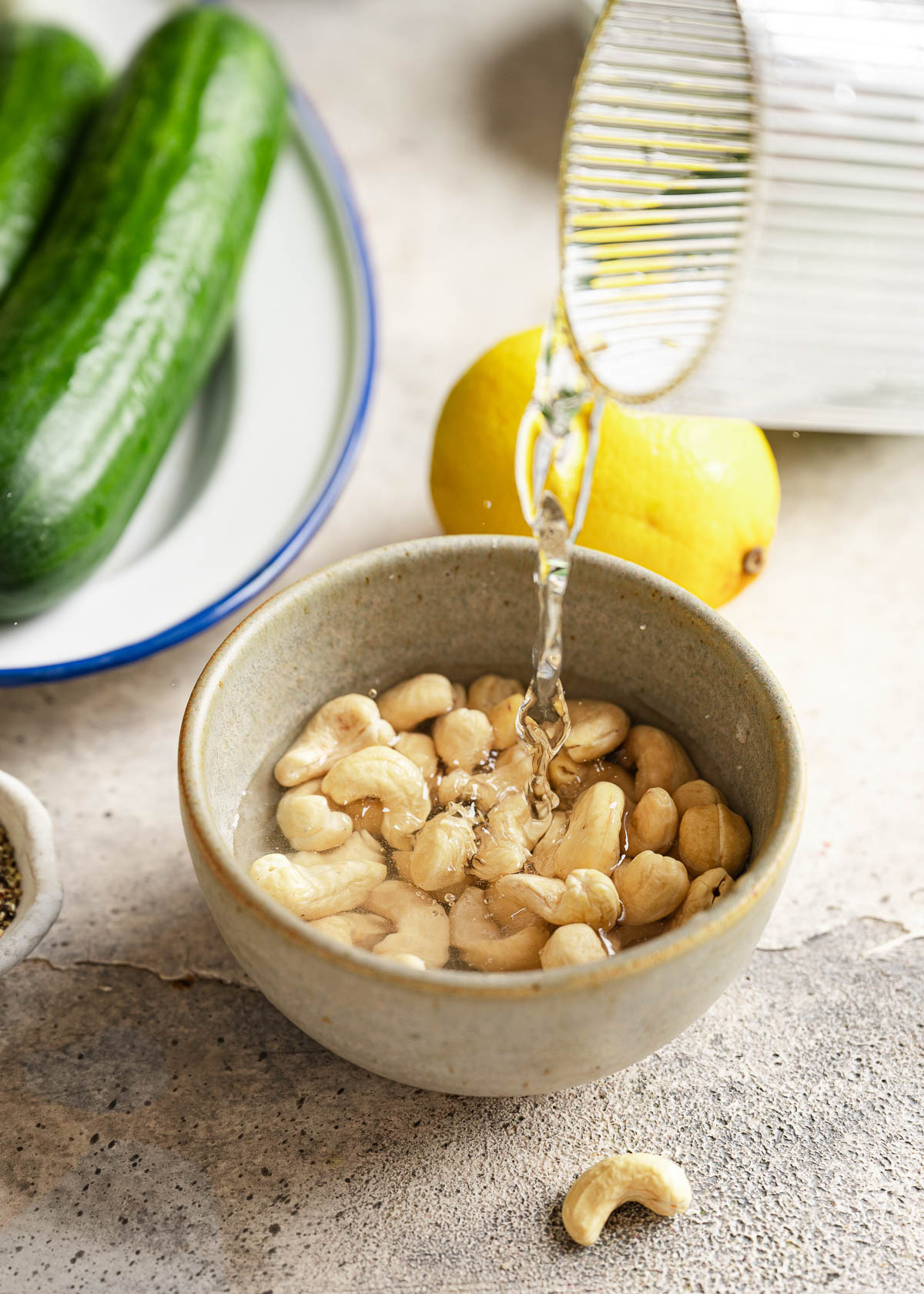 Water being poured on a bowl of cashews.