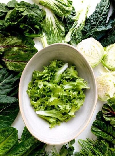 Bowl with romaine surrounded by leafy greens.