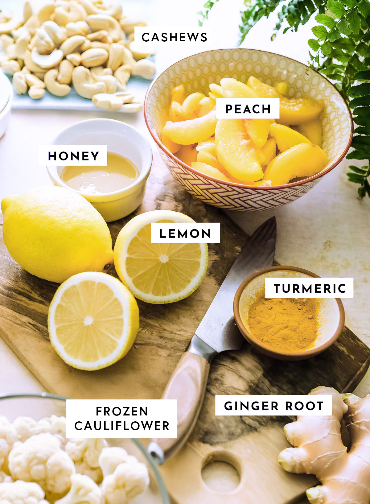 Lemon smoothie ingredients placed on a wooden chopping board over a kitchen countertop.