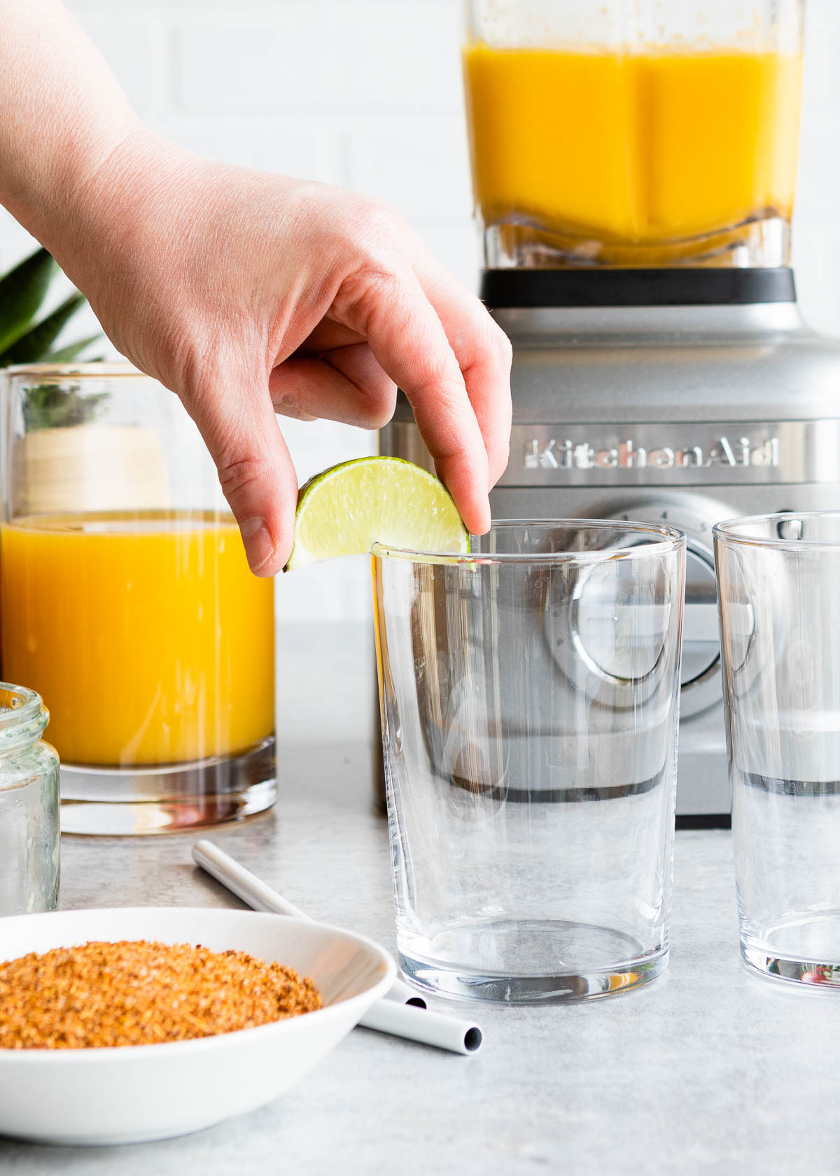 Running a lime wedge around the rim of a glass.