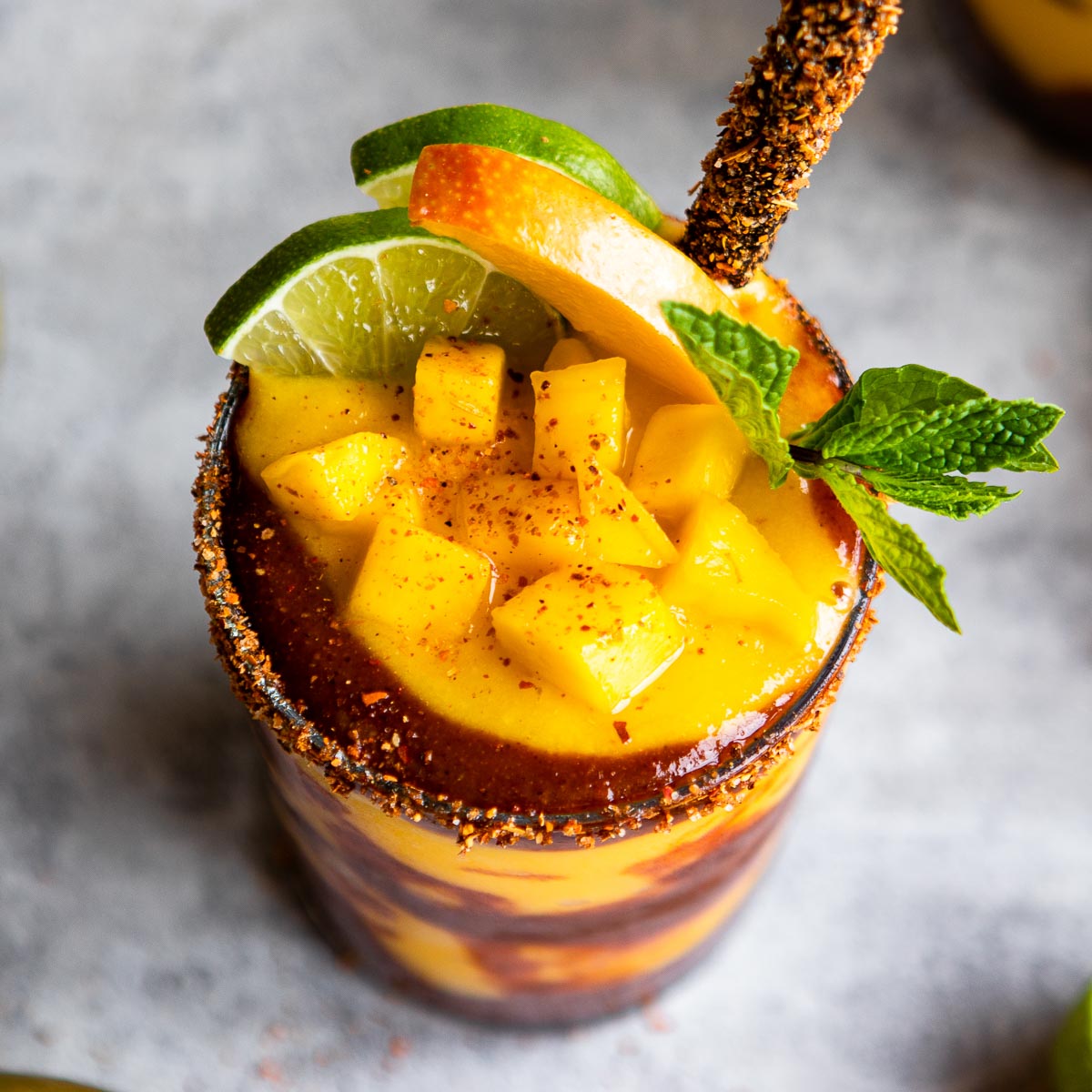 A glass of mangonada recipe with chamoy sauce and tamarind straw.
