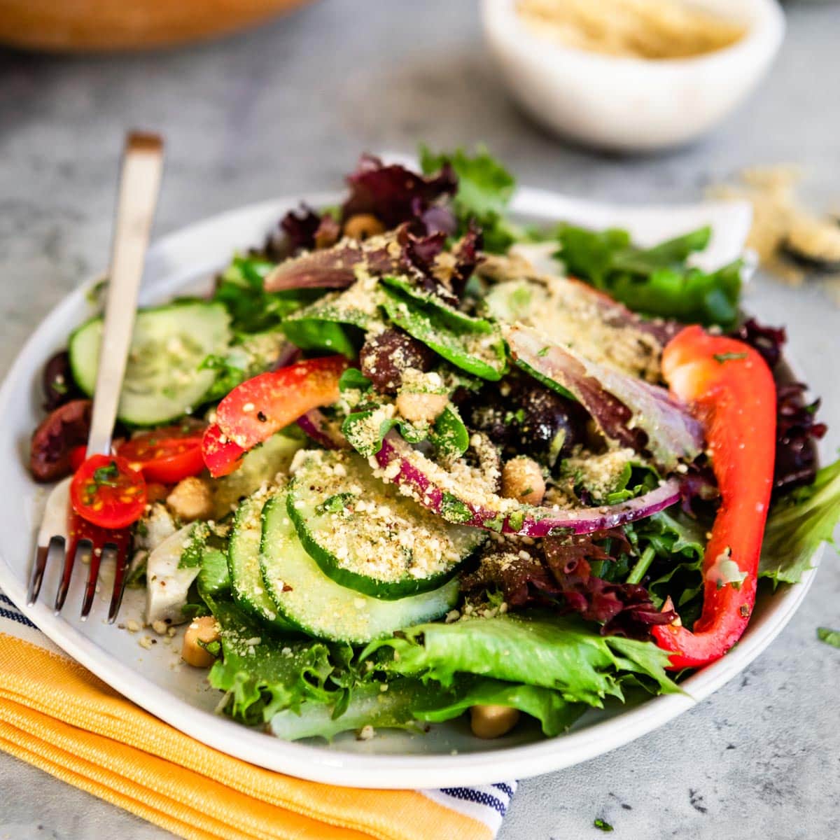 greek salad on a white plate with a fork.