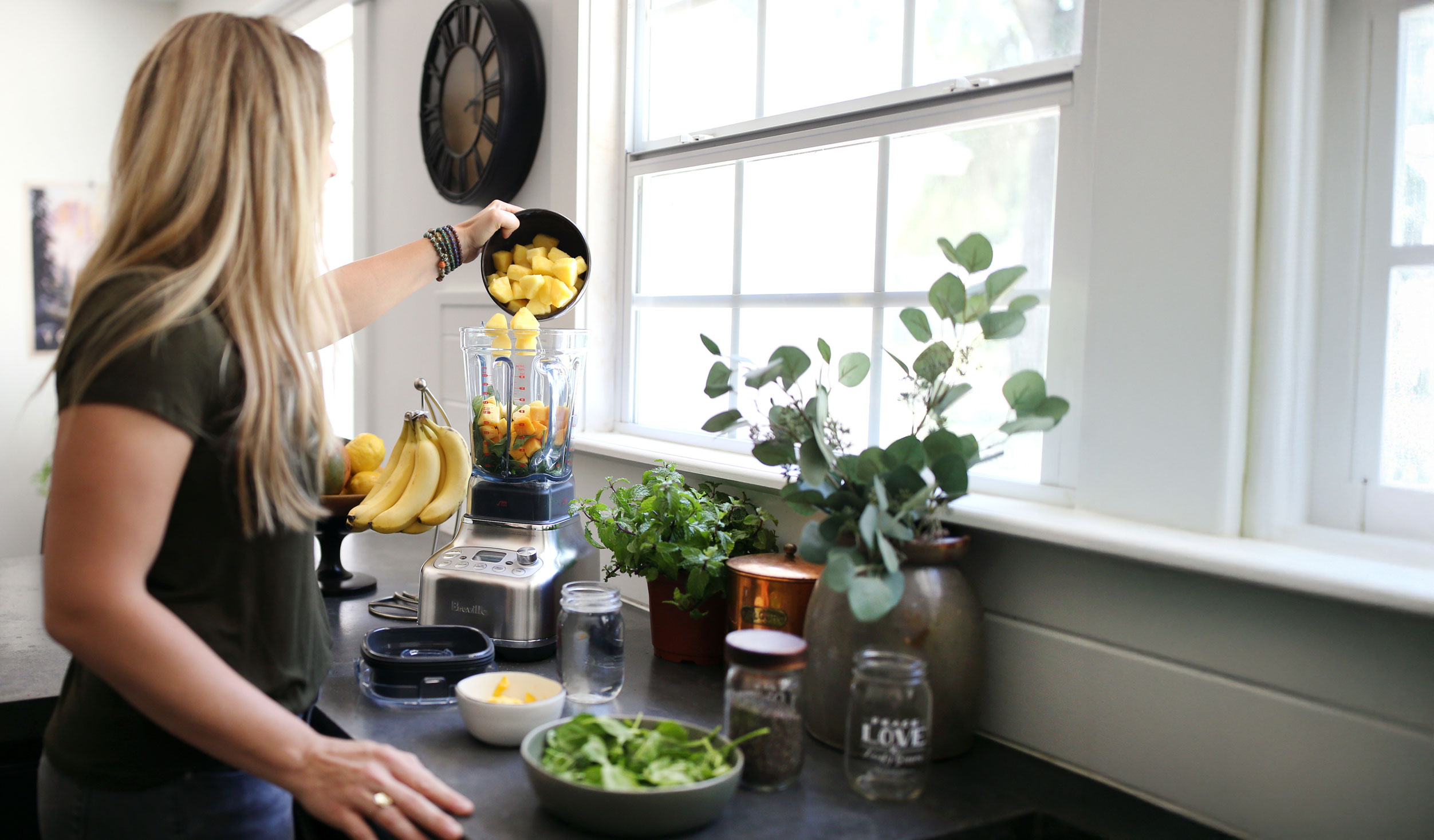 Jen in kitchen using plant-based meal planner to make smoothie.