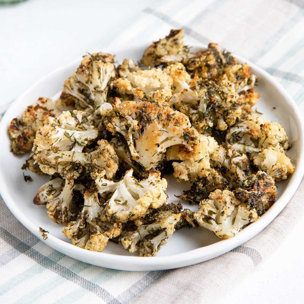 ranch cauliflower popcorn on a plate on a tea towel.