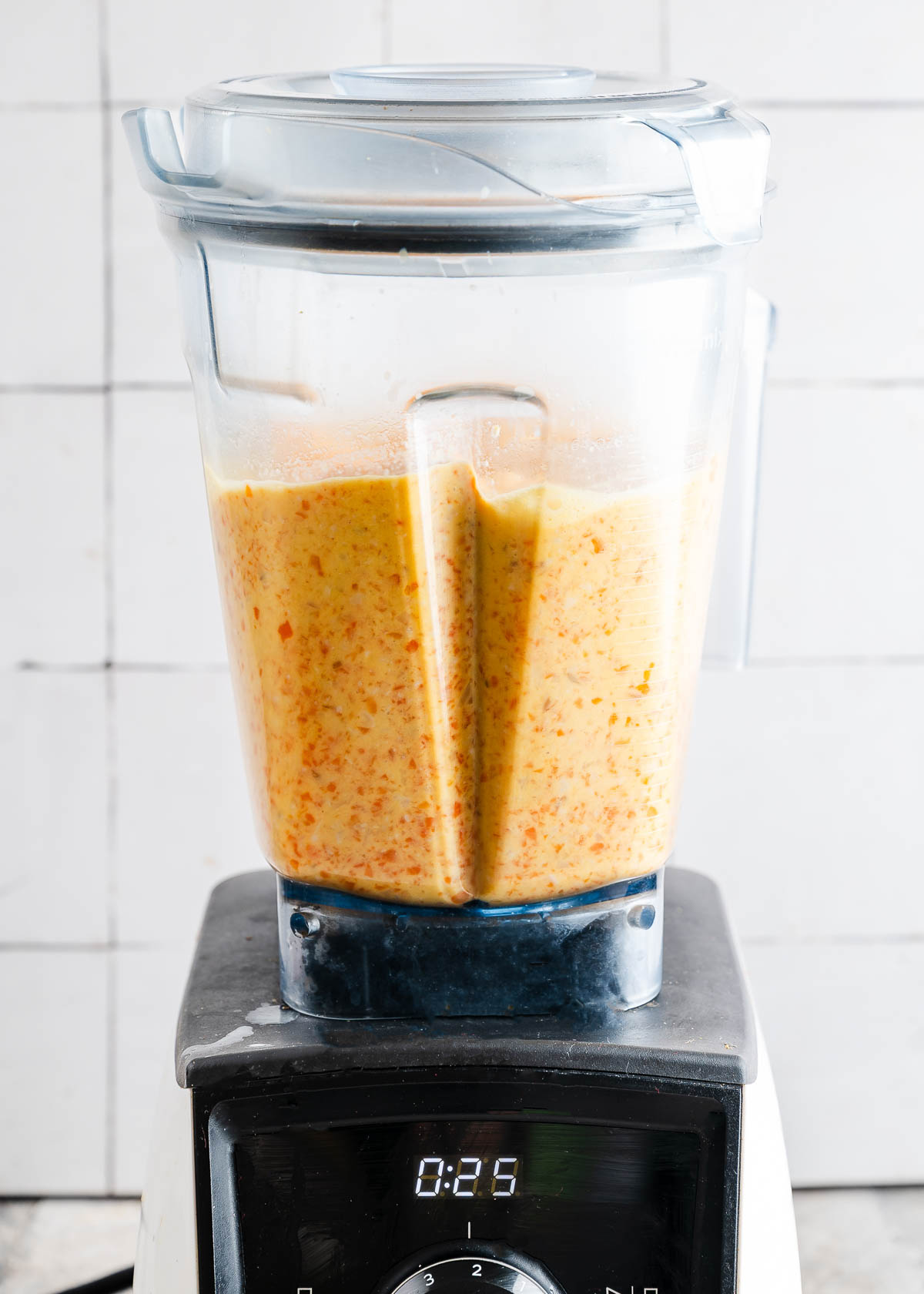 Carrot ginger soup getting blended up in a Vitamix.