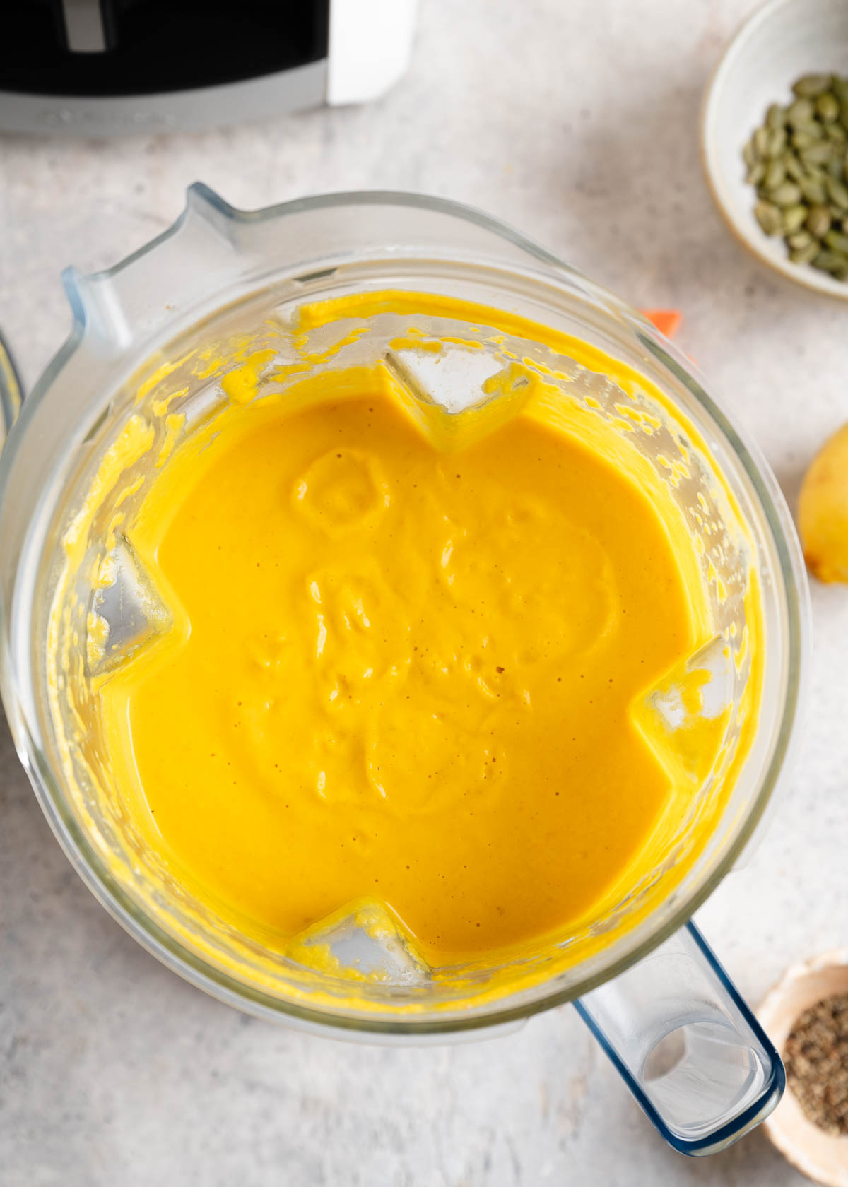 Blender container full of puréed carrot ginger soup.