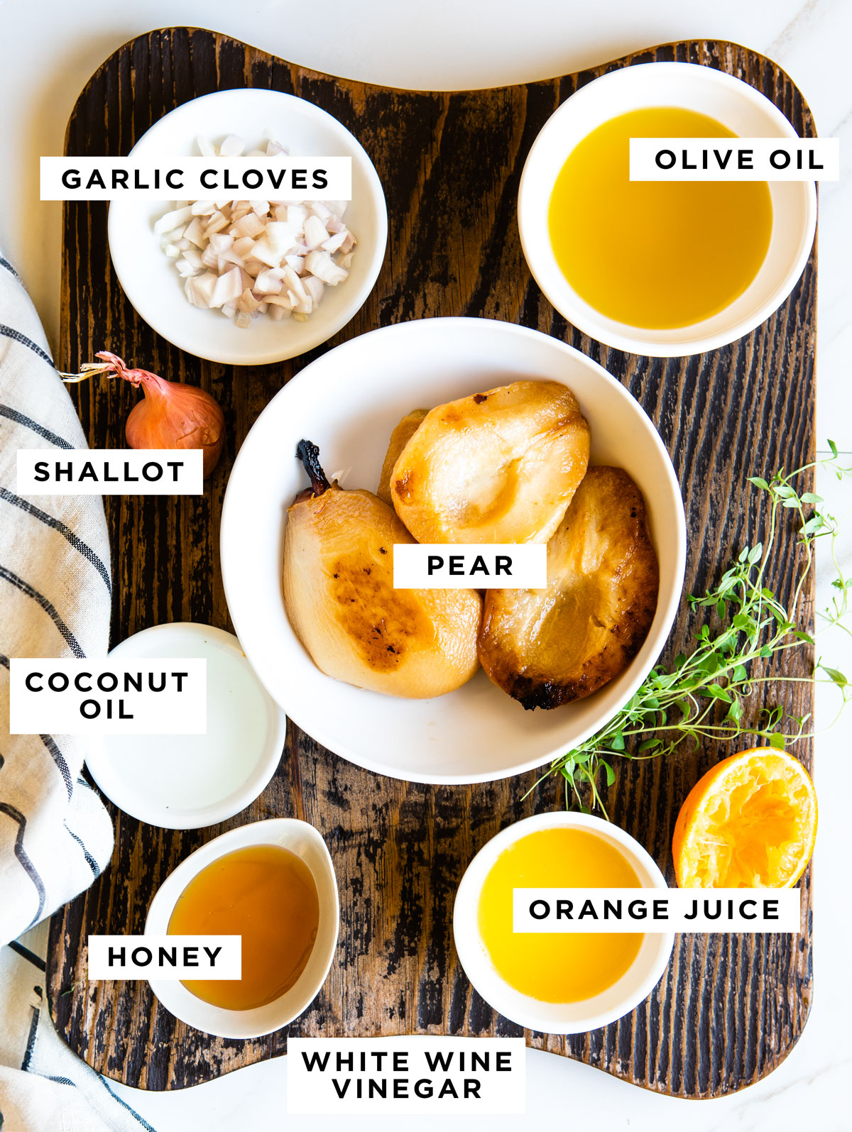 Ingredients for roasted pear vinaigrette on rustic wood cutting board.